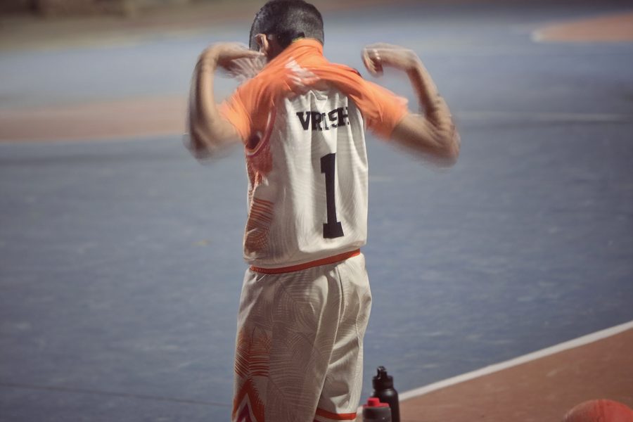 Vrishvardhan Sharma on a basketball court from behind, arms raised, his jersey reading VRISH 1.