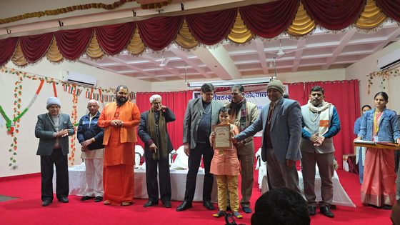 Vrishvardhan Sharma receiving his certificate on stage from a row of scholars and officials at Central Sanskrit University, Jaipur.