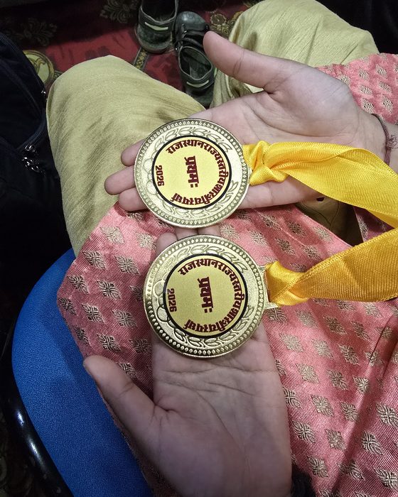 Two gold medals inscribed Rajasthan state level Shastriya competition 2026, first place.