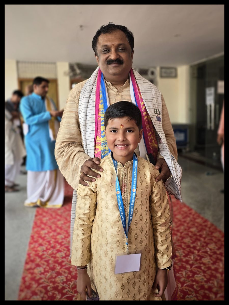 Vrishvardhan Sharma with Prof. Srinivasa Varakhedi, Vice Chancellor of Central Sanskrit University, wearing an All India Elocution Contest lanyard.