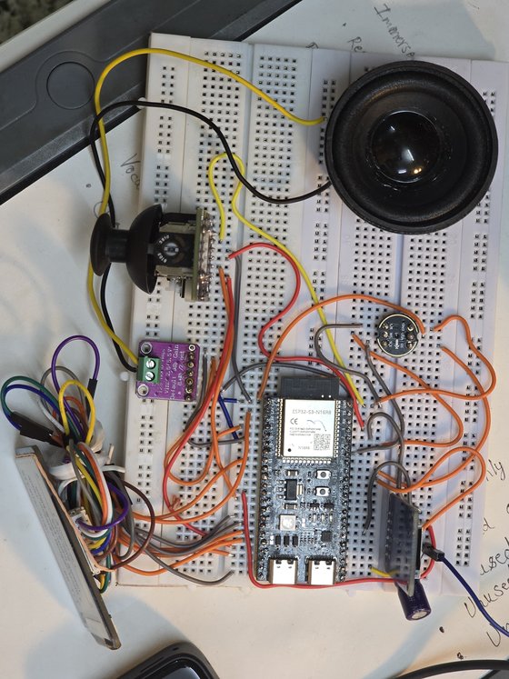 A breadboard circuit mid build, with a microcontroller, amplifier module, microphone and small speaker wired together.